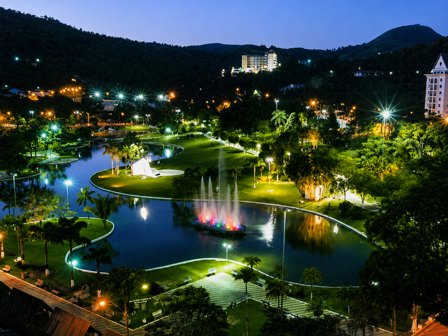 Praça Adhemar de Barros com lago e prédios refletidos na água em Águas de Lindóia, São Paulo